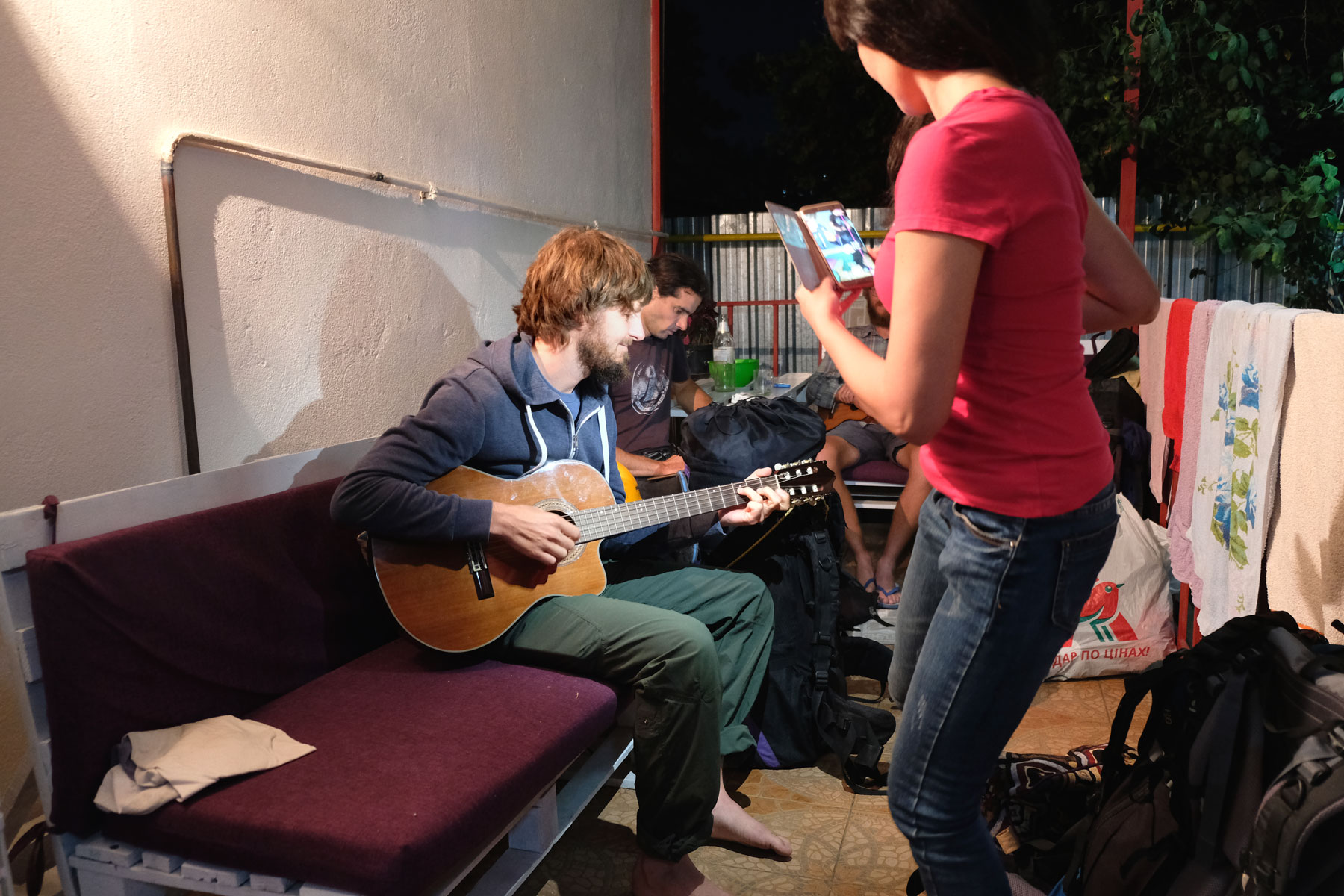 Sebastian spielt Gitarre. Eine Frau filmt ihn mit ihrem Smartphone.