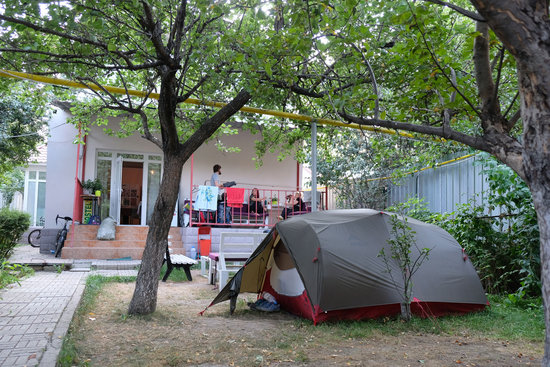 Ein Zelt steht im Garten eines Hostels.