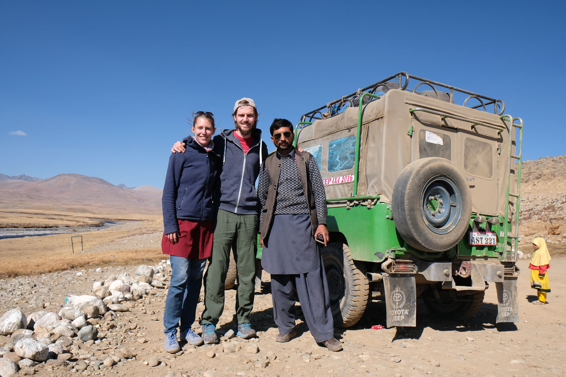 Leo und Sebastian mit einem Pakistaner neben einem Geländewagen auf dem Deosai Plateau.