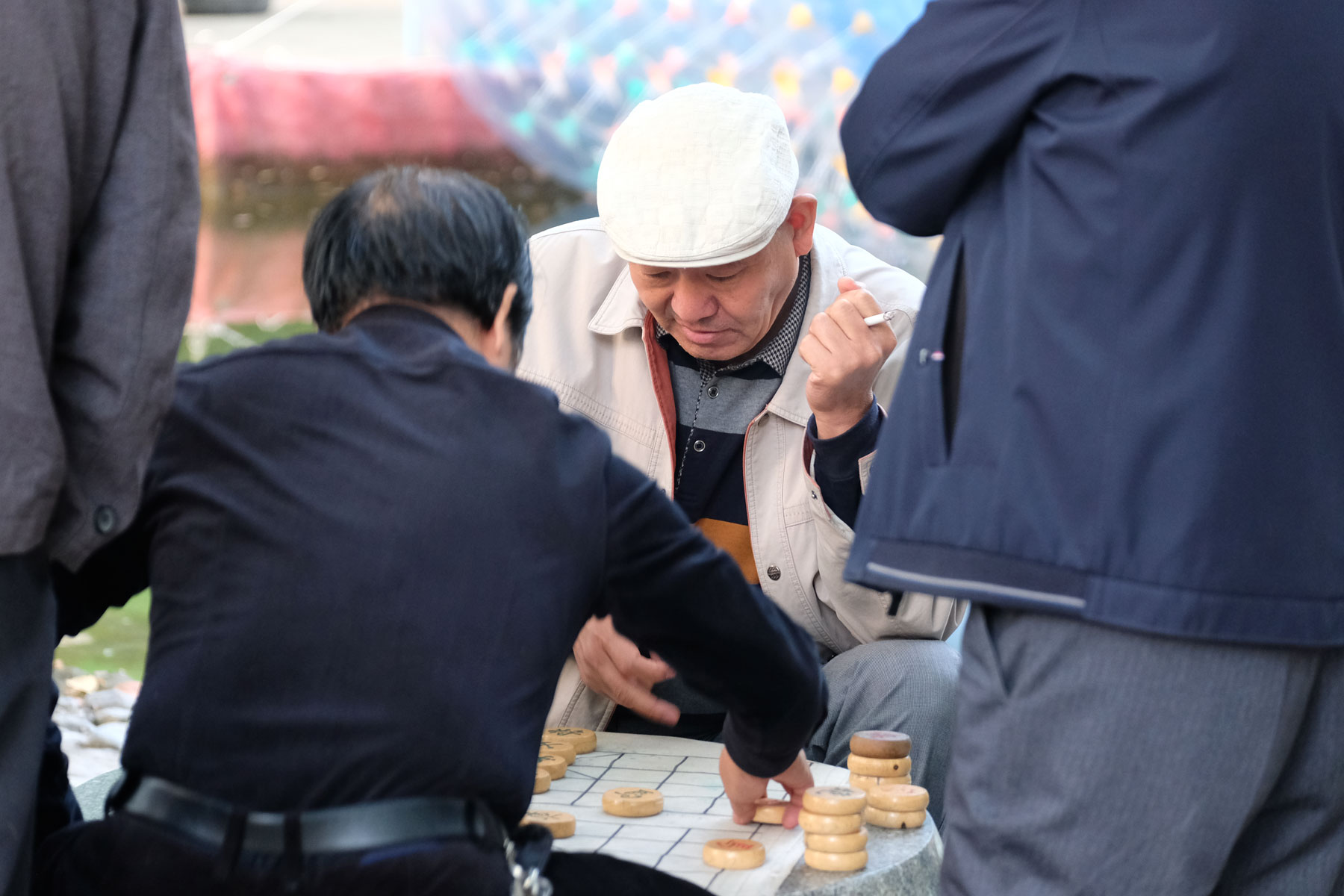 Chinesische Männer spielen ein Brettspiel.