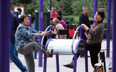 Chinesische Frauen machen Leibesübungen an einem Sportgerät im Park.