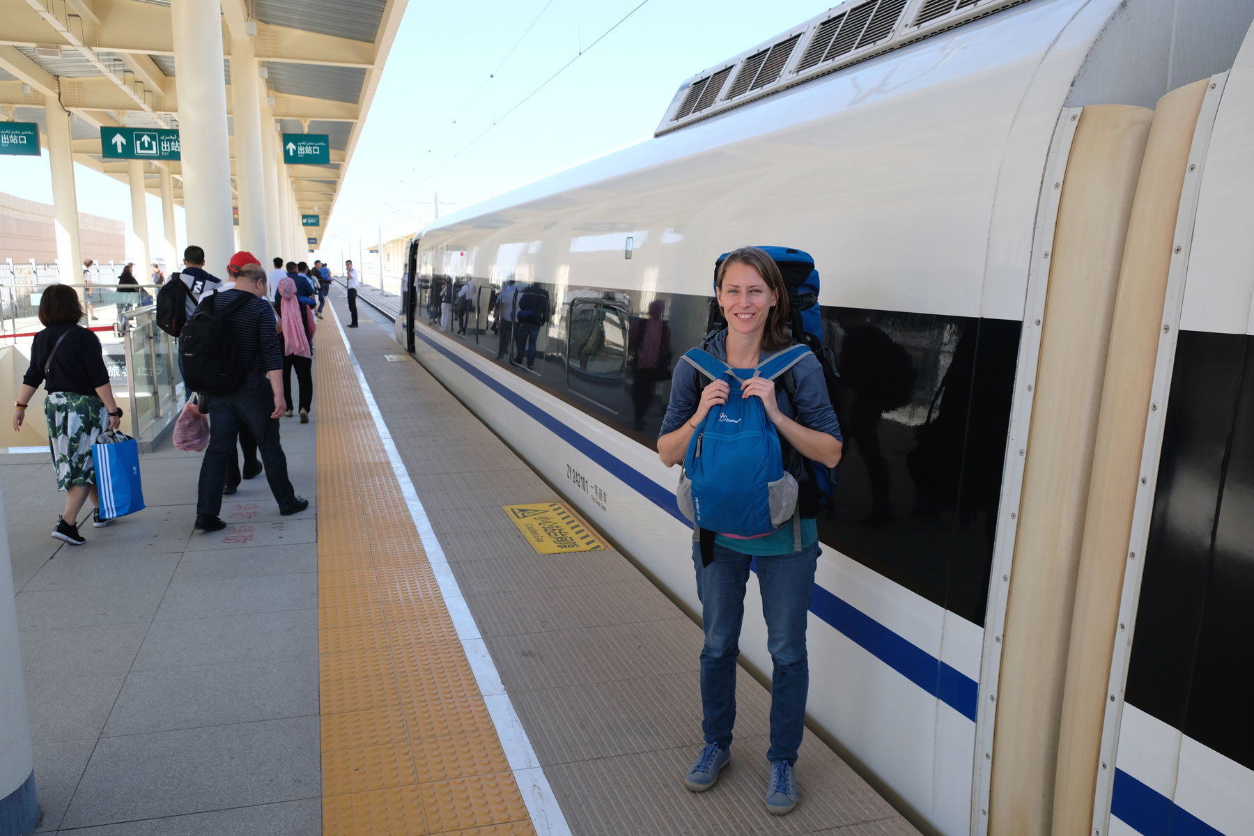 Leo vor einem Zug im Bahnhof von Turpan.