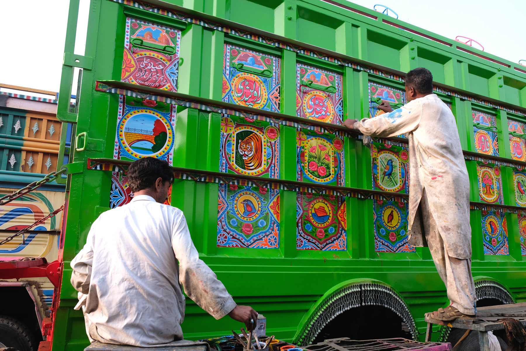 Zwei Männer bemalen einen Lastwagen in Rawalpindi.