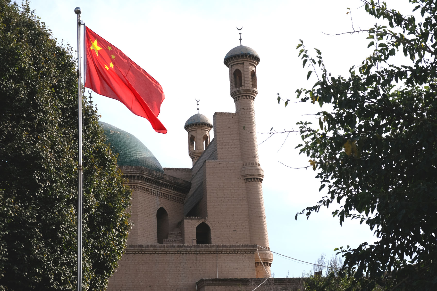 Chinesische Fahne vor Moschee in Kucha.