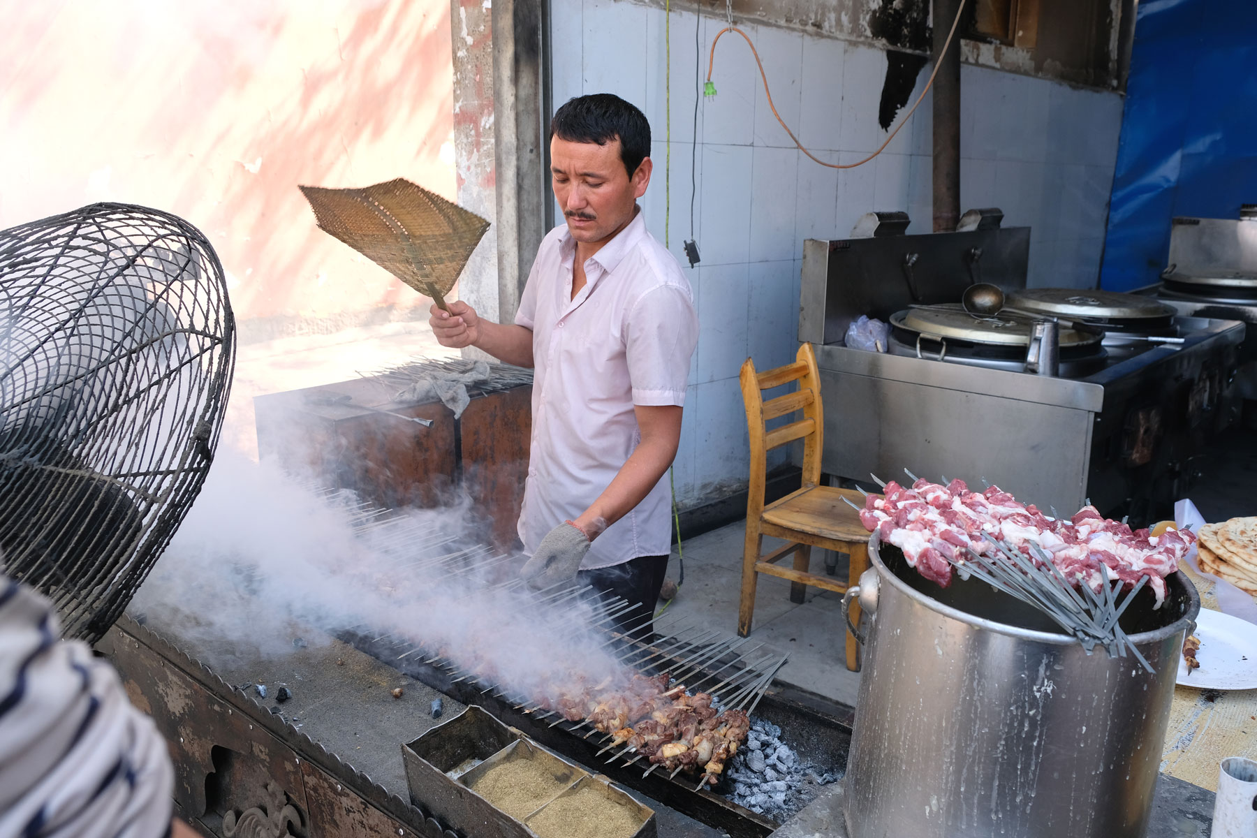 Ein Mann bereitet Kebabspieße zu.