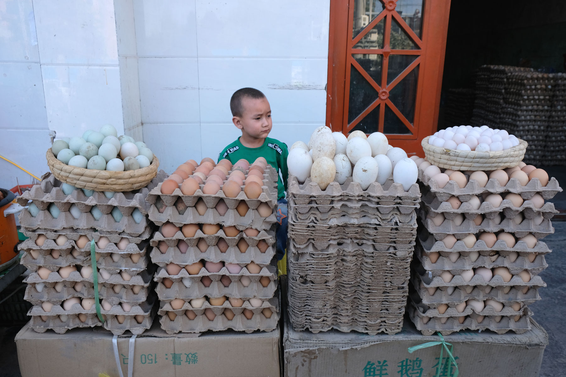 Ein Junge an einem Eierstand in Hotan.
