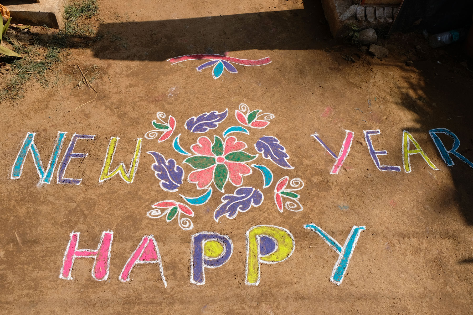 Mit bunten Farben wurden die Worte "Happy new year" auf den Boden gemalt.