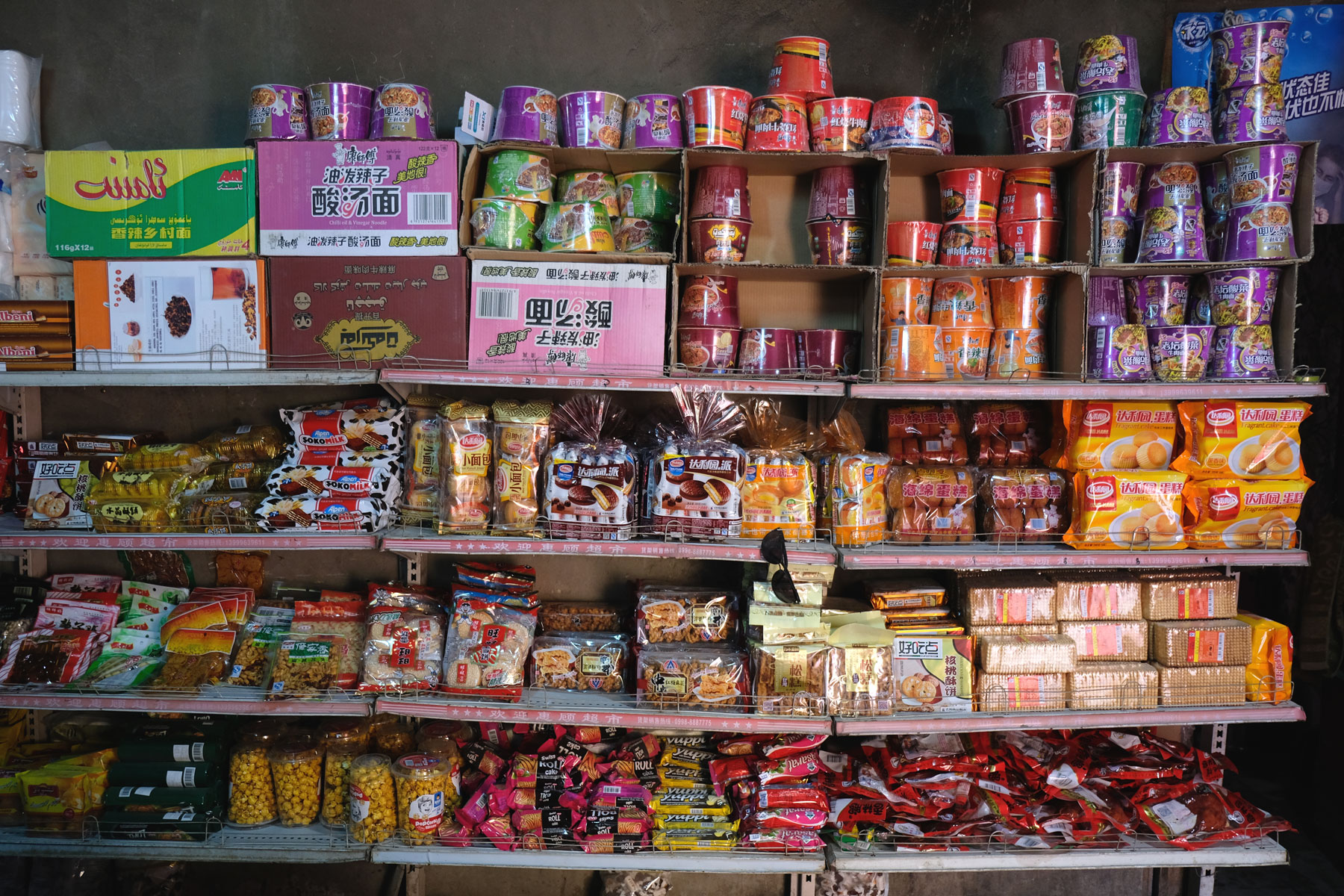 Chinesische Suppen und Süßigkeiten in einem Supermarktregal.