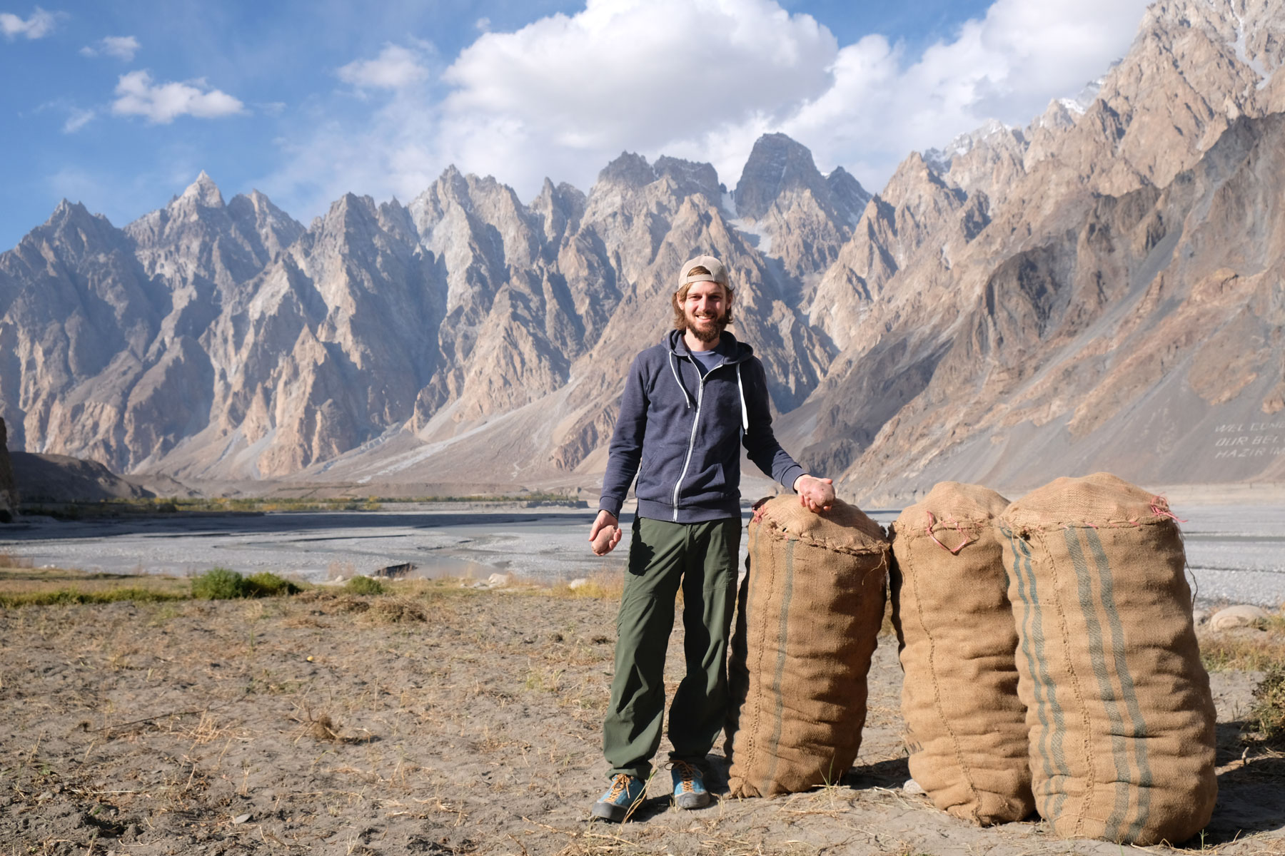 Sebastian neben drei Kartoffelsäcken im pakistanischen Karakorum.