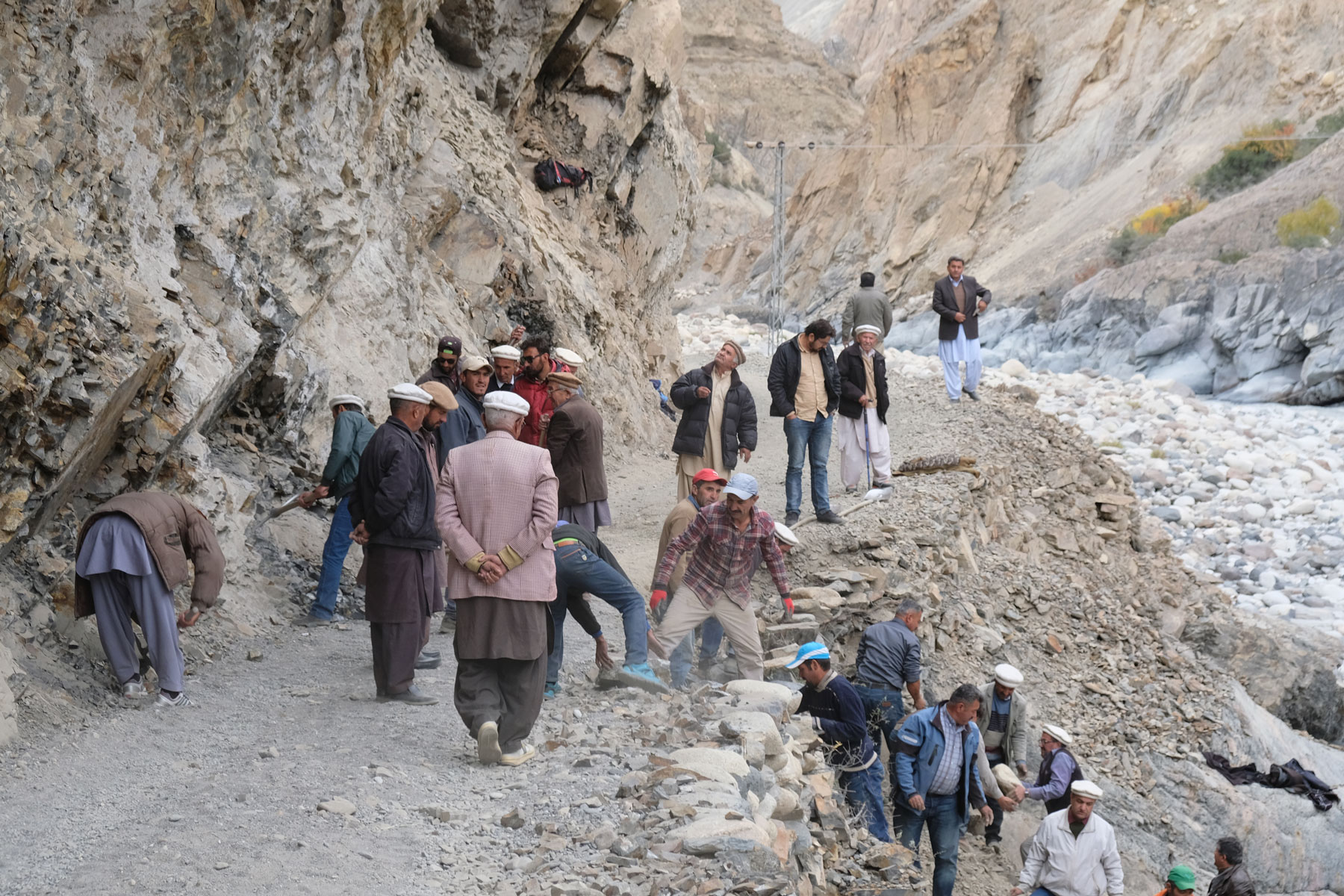 Pakistanische Männer reparieren eine Gebirgsstraße im Karakorumgebirge.