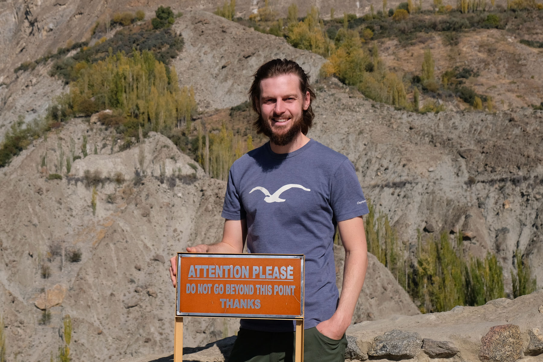 Sebastian steht hinter einem Schild, auf dem steht, dass man ab diesem Punkt nicht weitergehen soll.