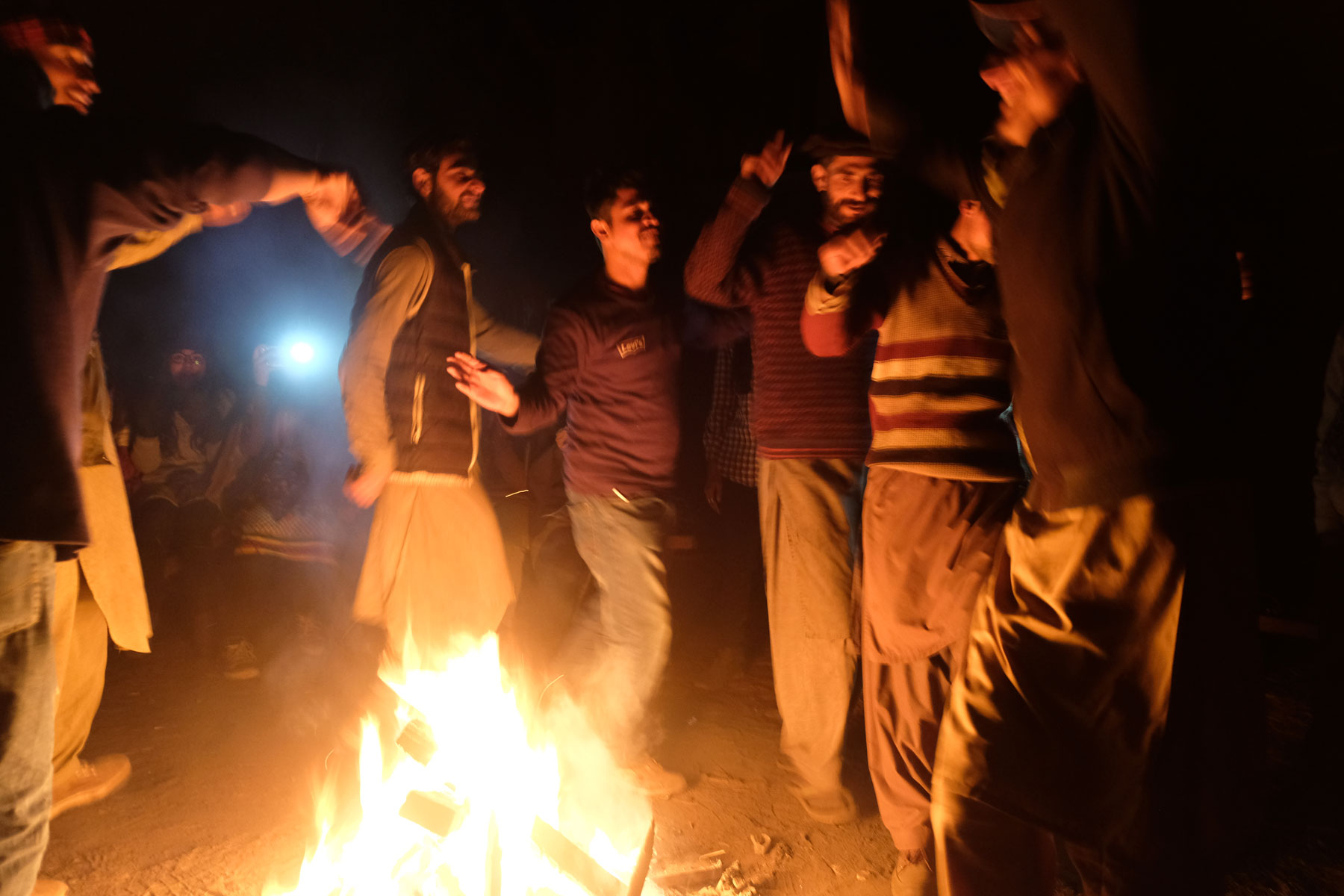 Männer tanzen in Fairy Meadows um ein Lagerfeuer.