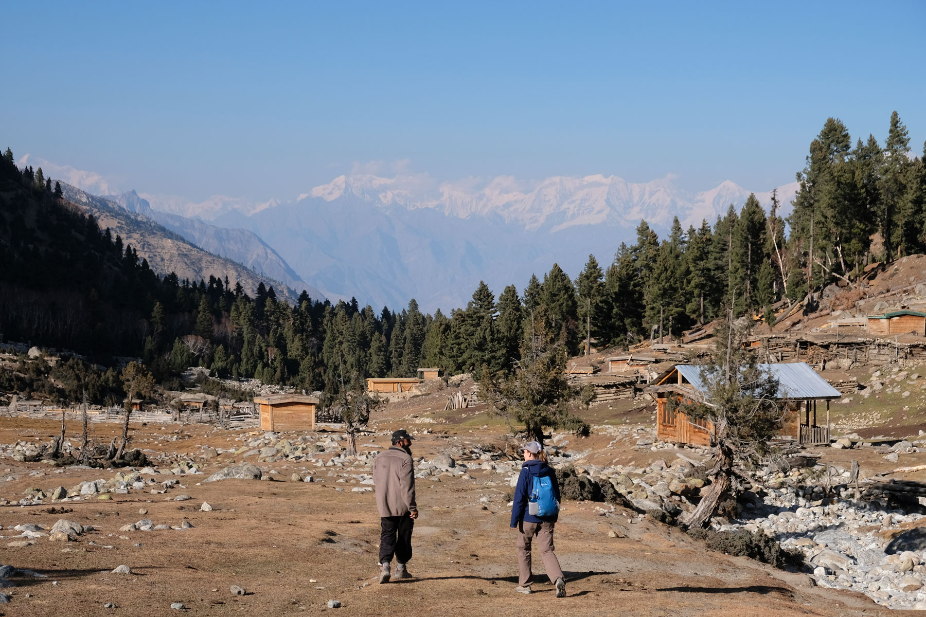 Leo geht neben einem pakistansichen Mann im Gebirge.