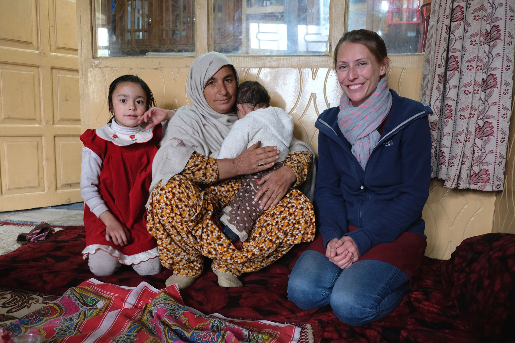 Leo neben einer pakistanischen Frau, die ein Baby auf dem Arm hält.