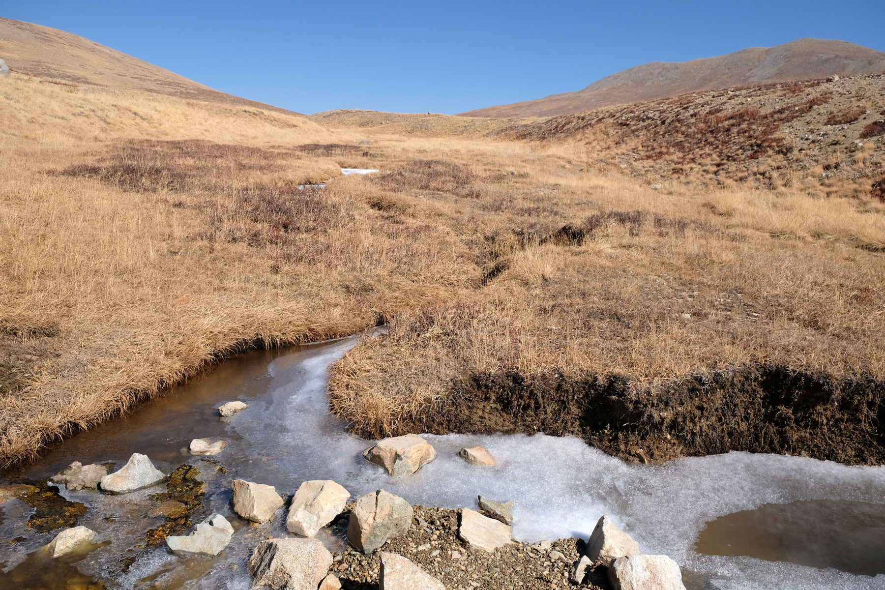 Zugefrohrener Bach auf den Deosai Plains.