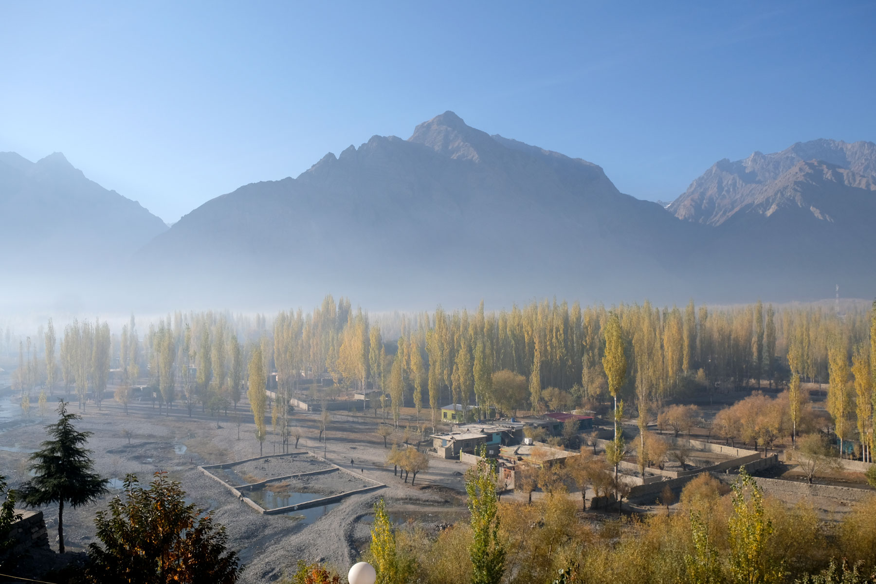 Skardu mit herbstlichen Laubbäumen.