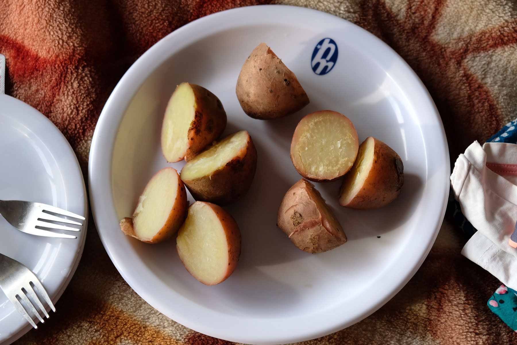 Ein Teller mit halbierten Pellkartoffeln.