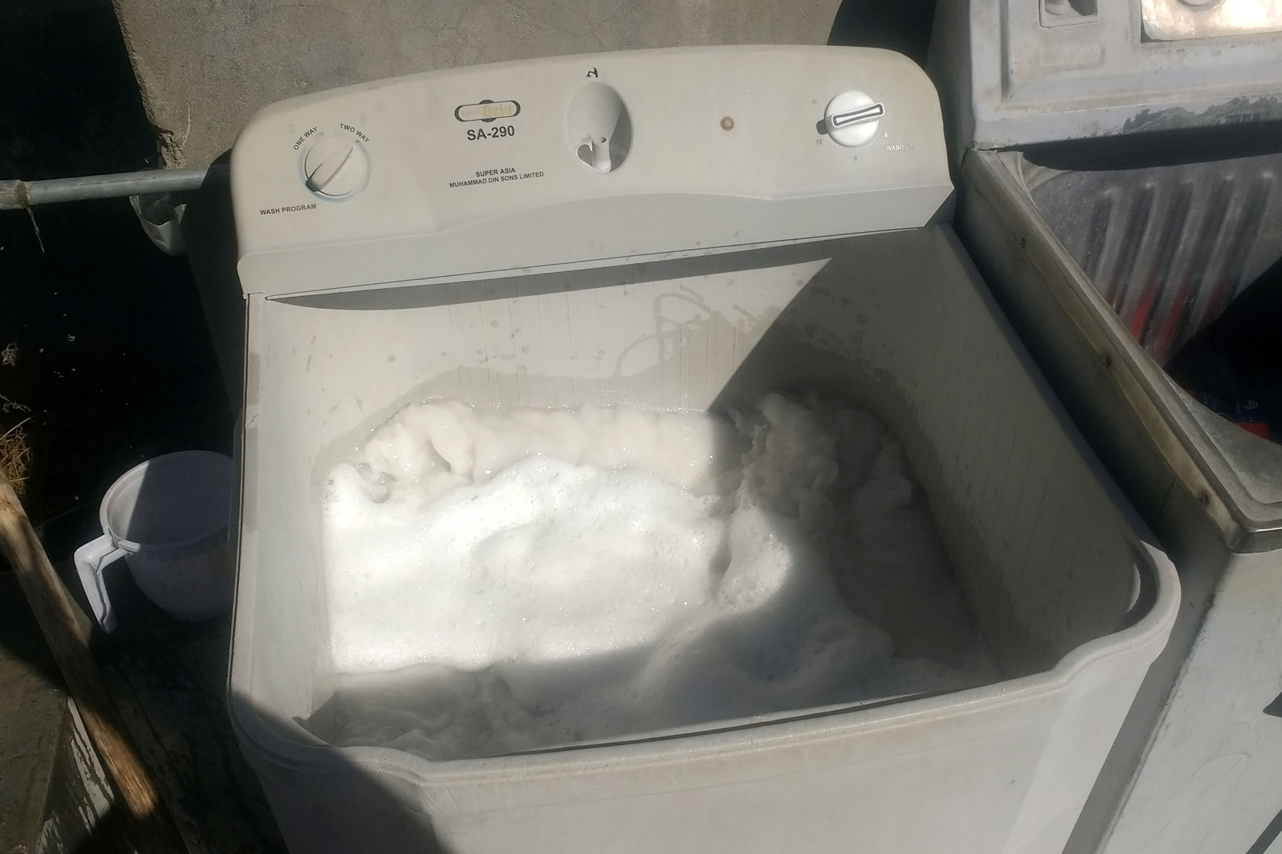 Eine Waschmaschine ohne Deckel, in der man Schaum sieht.