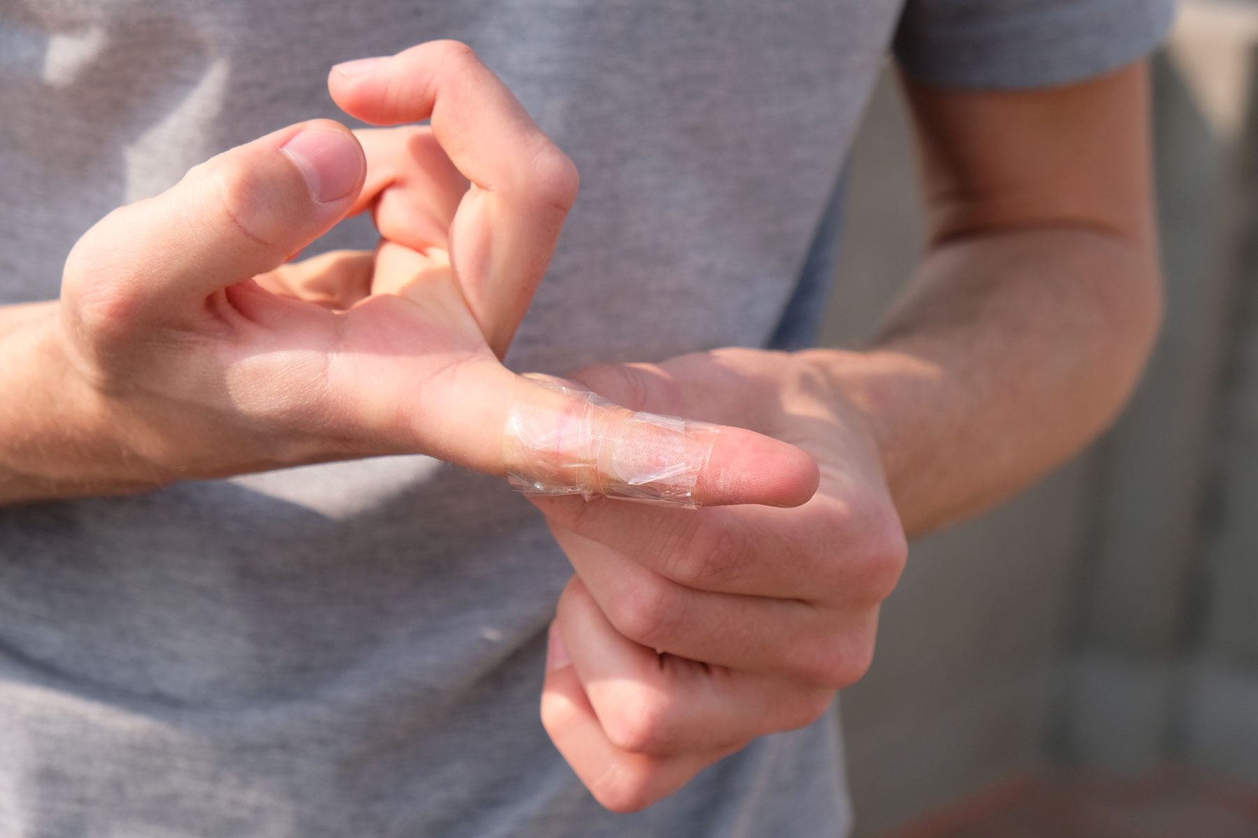 Ein Finger, der mit durchsichtigem Klebeband umwickelt ist.