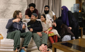 Sebastian zeigt einer pakistanischen Familie ein Fotoalbum.