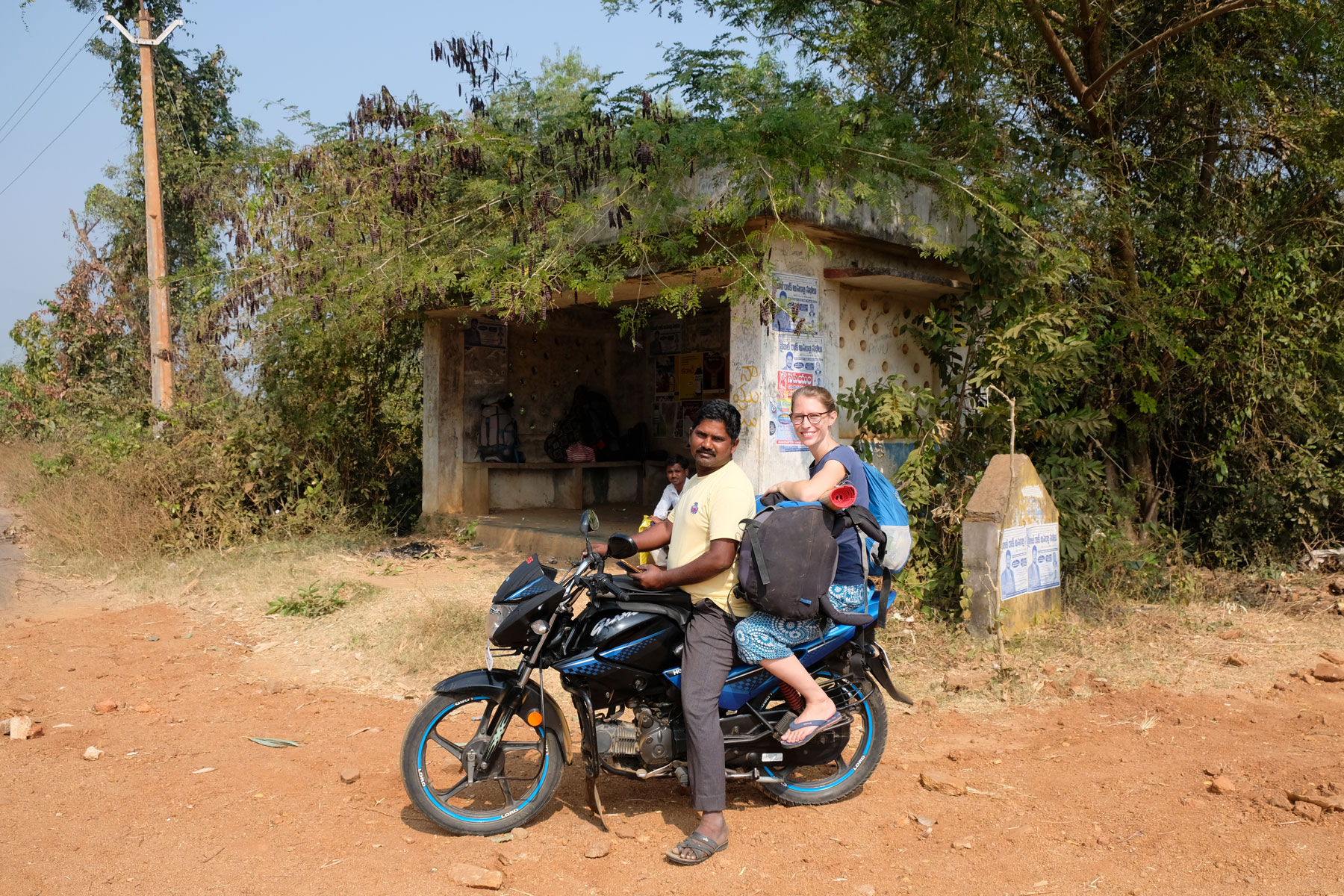 Leo sitzt mit einem Reiserucksack auf dem Rücksitz eines Motorrads.