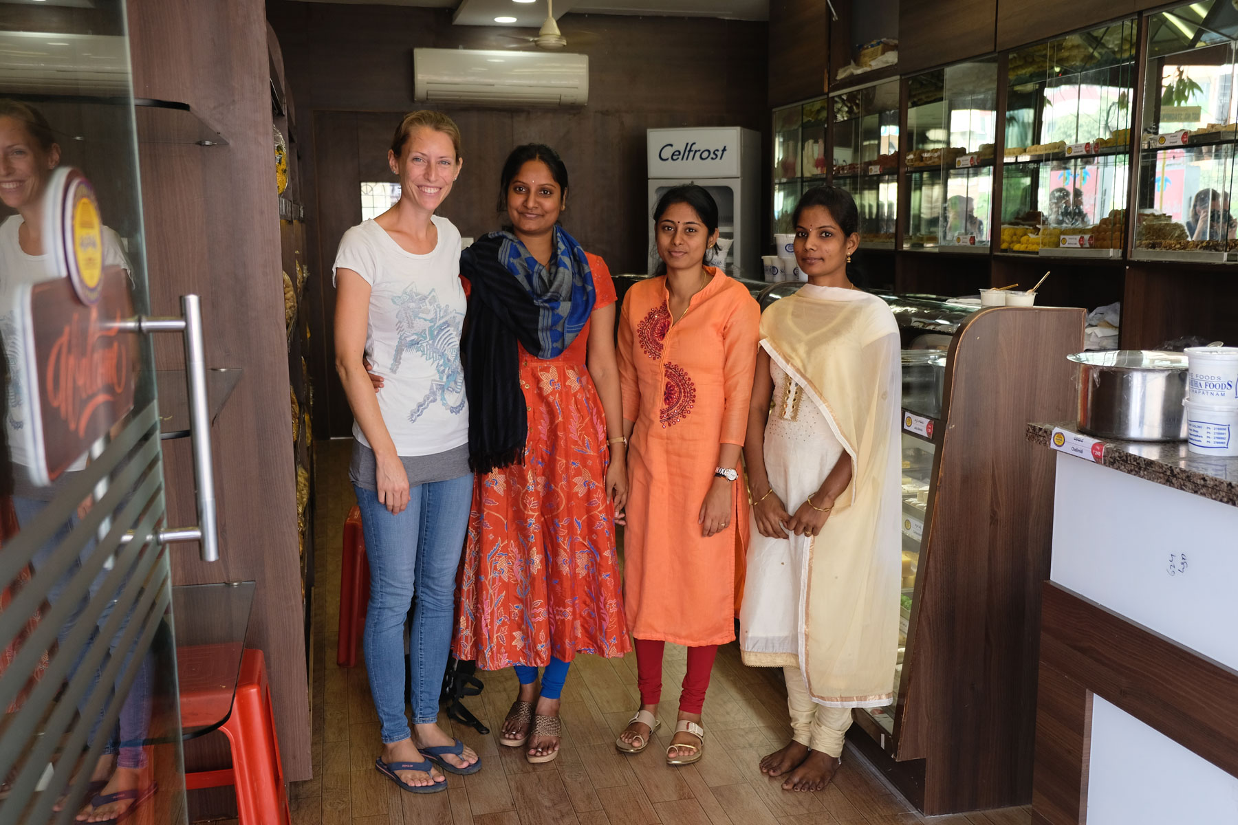 Leo neben drei indischen Frauen in einer Bäckerei in Visakhapatnam.