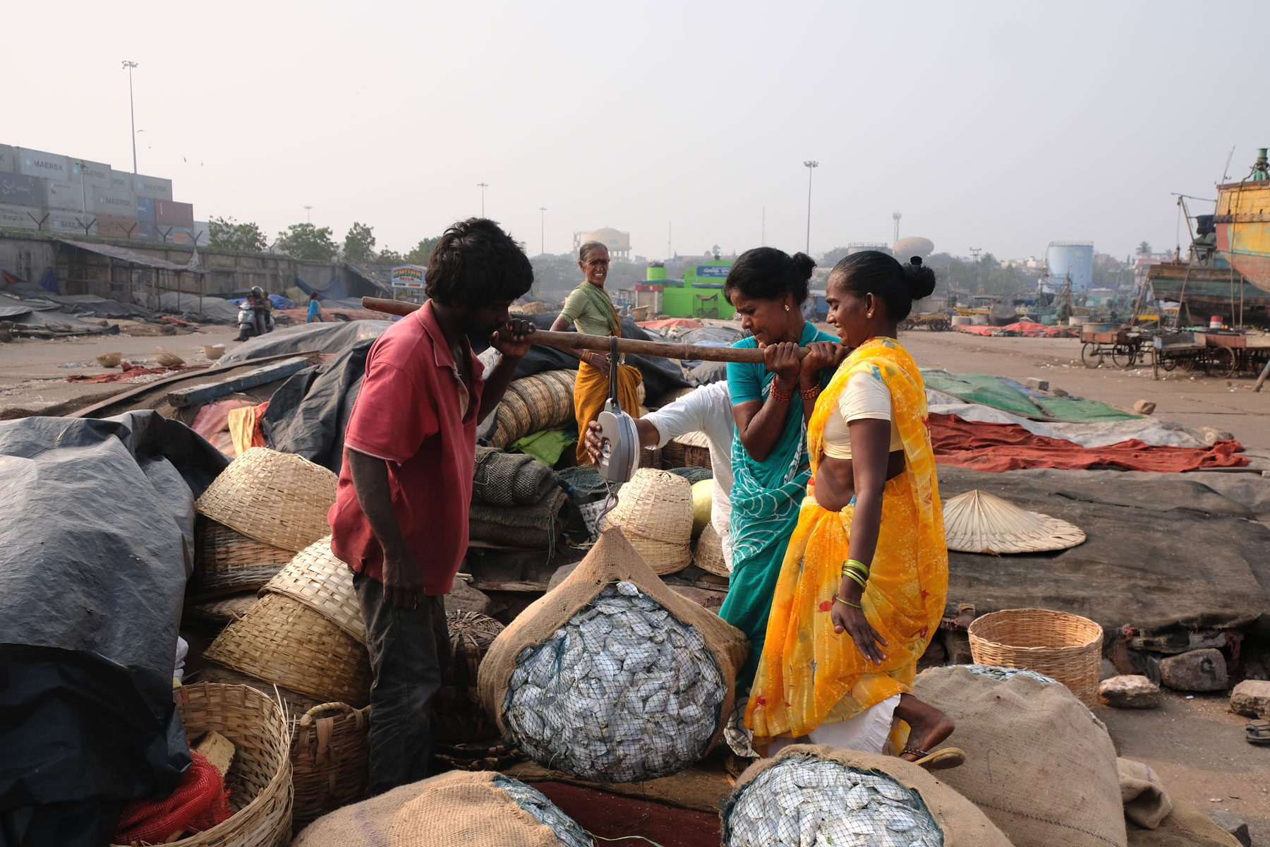 Indische Menschen wiegen am Hafen von Visakhapatnam getrockneten Fisch.