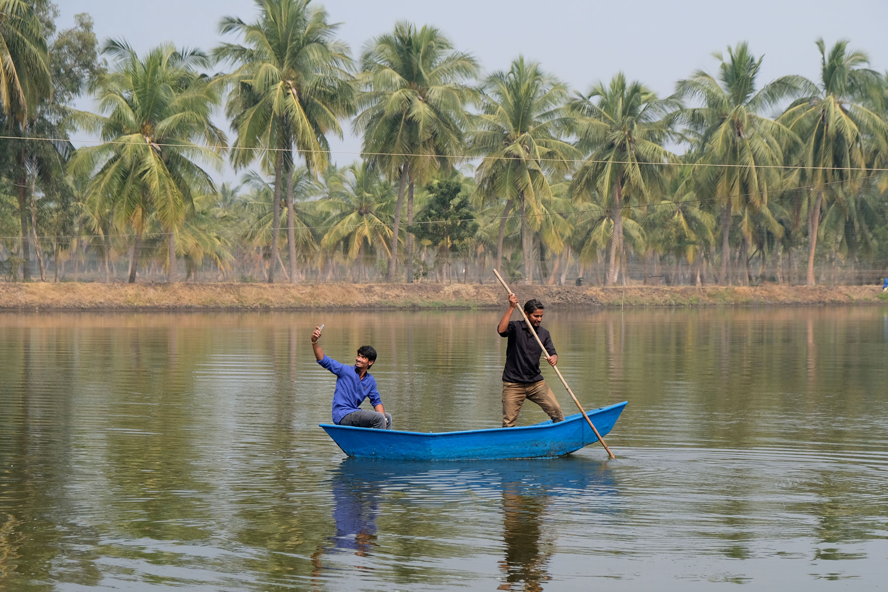 Zwei indische Männer in einem kleinen Boot auf einem See.