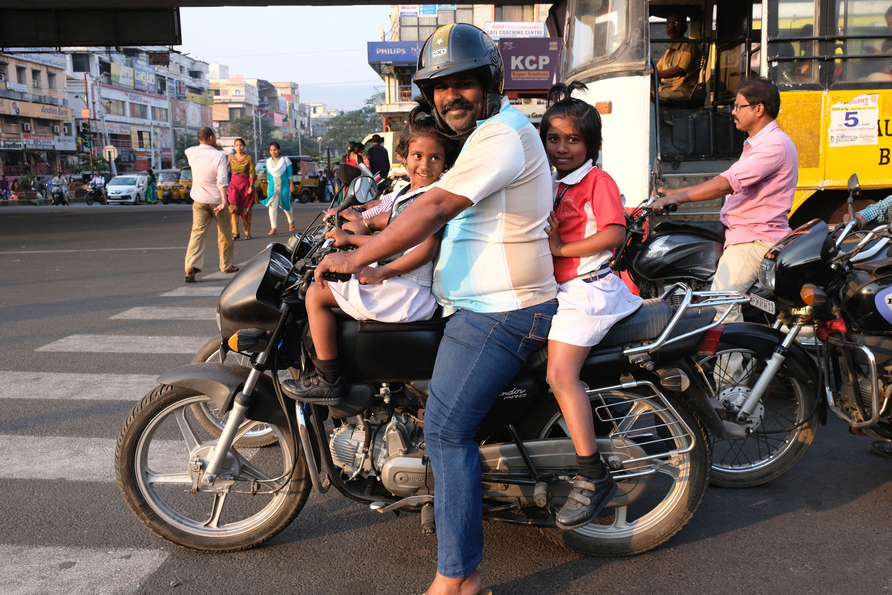 Ein indischer Mann und zwei Mädchen sitzen in Visakhapatnam auf einem Motorrad.