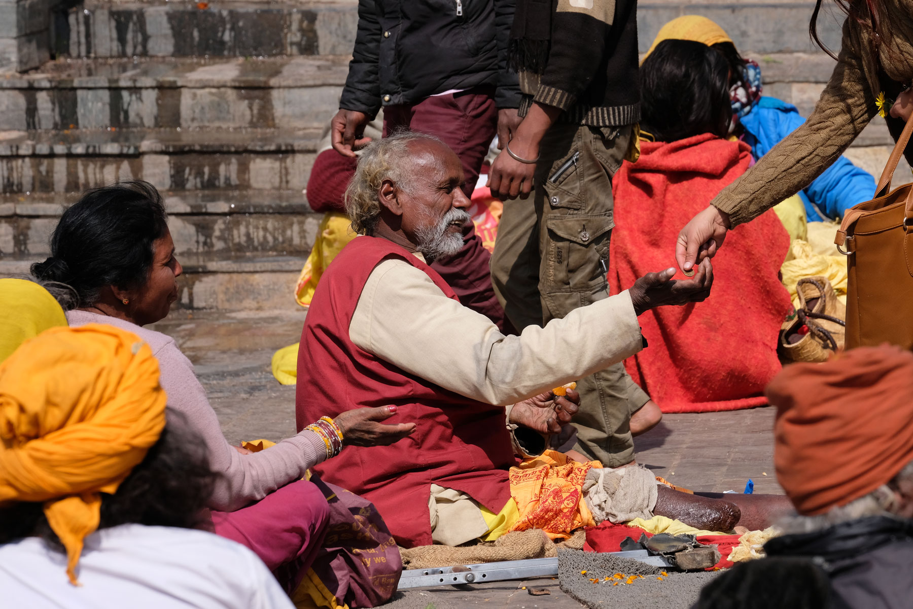 Bedürftige empfangen auf einem Platz in Pashupatinath Spenden.