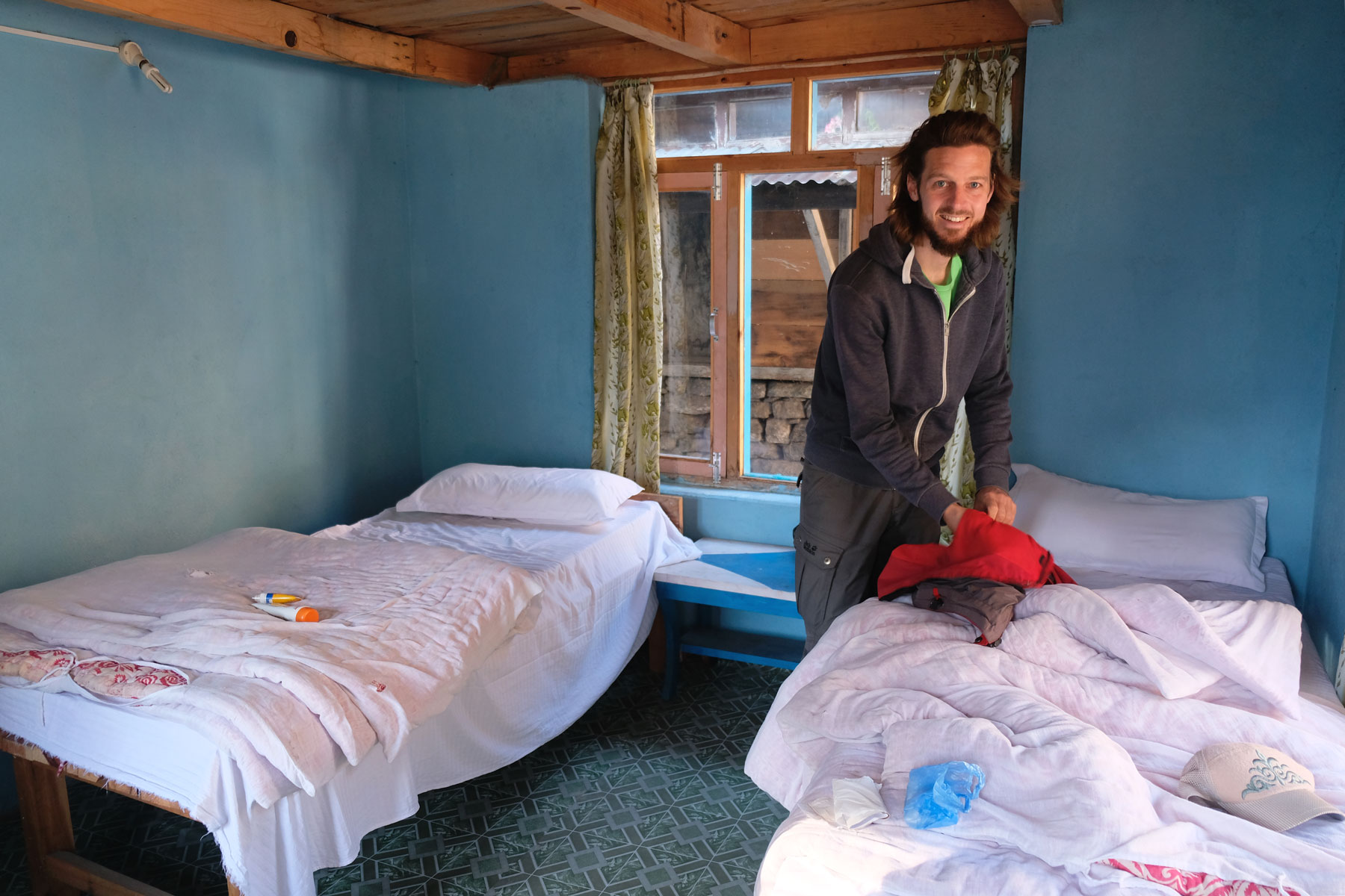 Sebastian in einem Zimmer mit zwei Betten.