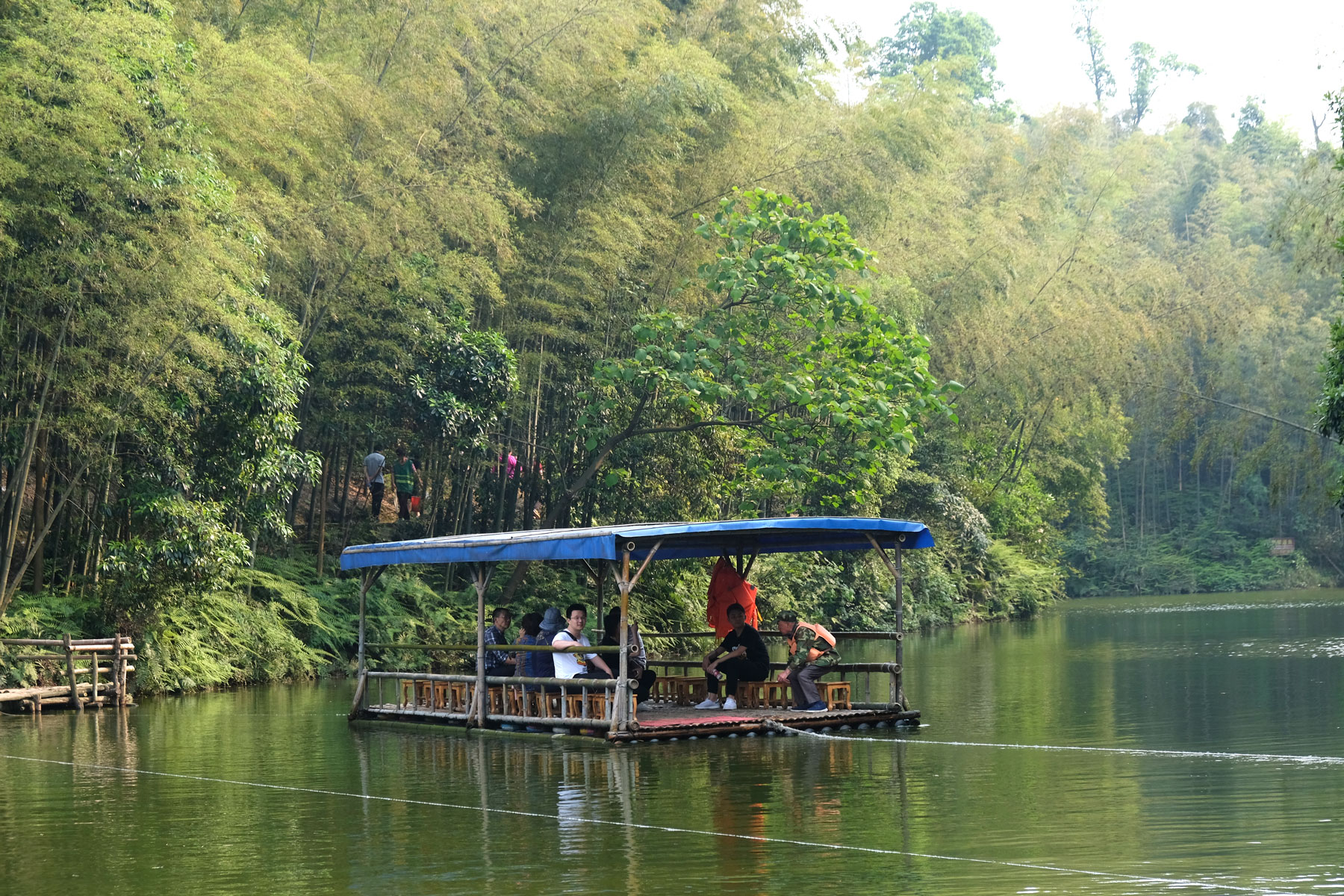 Ein Floß fährt auf einem See im Shunan Zhuhai Nationalpark.