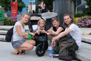 Sebastian sitzt neben Leos Freundinnen Anke und Vera und der kleinen Greta, die im Kinderwagen sitzt