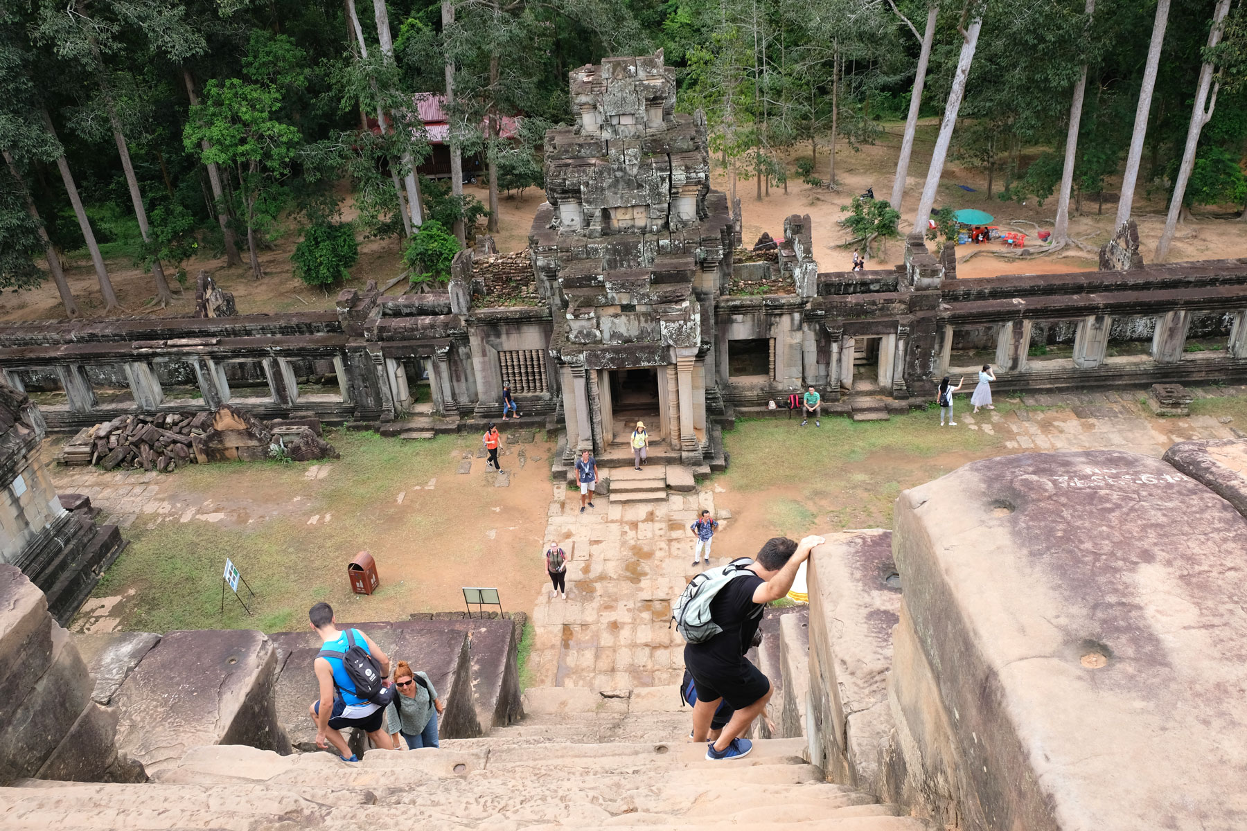 Menschen laufen vorsichtig die extrem steilen und schmalen Stufen des Tempels Ta Keo in Angkor Wat hinunter