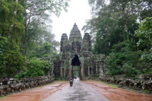 Ein Motorroller fährt aus dem Victory Gate in Angkor Wat.