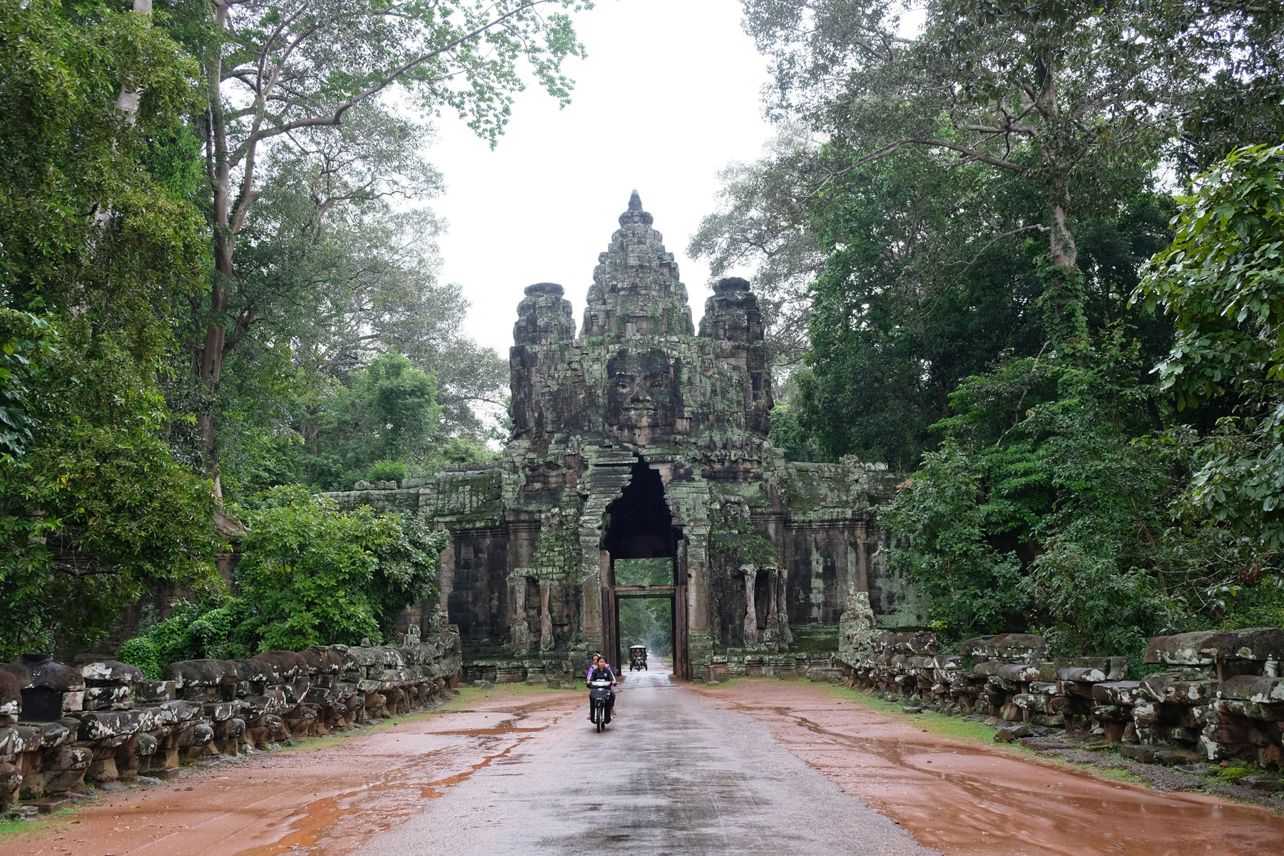 Ein Motorroller fährt aus dem Victory Gate in Angkor Wat.