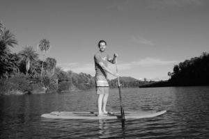Sebastian steht auf einem Standup-Board auf dem Fluss von San Ignacio, Baja California, Mexiko.
