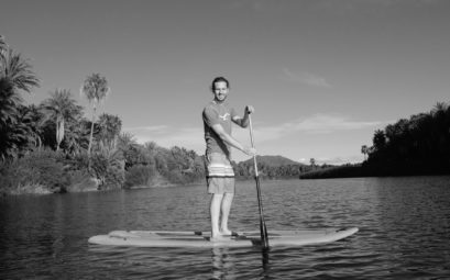 Sebastian steht auf einem Standup-Board auf dem Fluss von San Ignacio, Baja California, Mexiko.