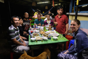 Leo sitzt mit einer Gruppe Vietnamesen am Abendessenstisch.