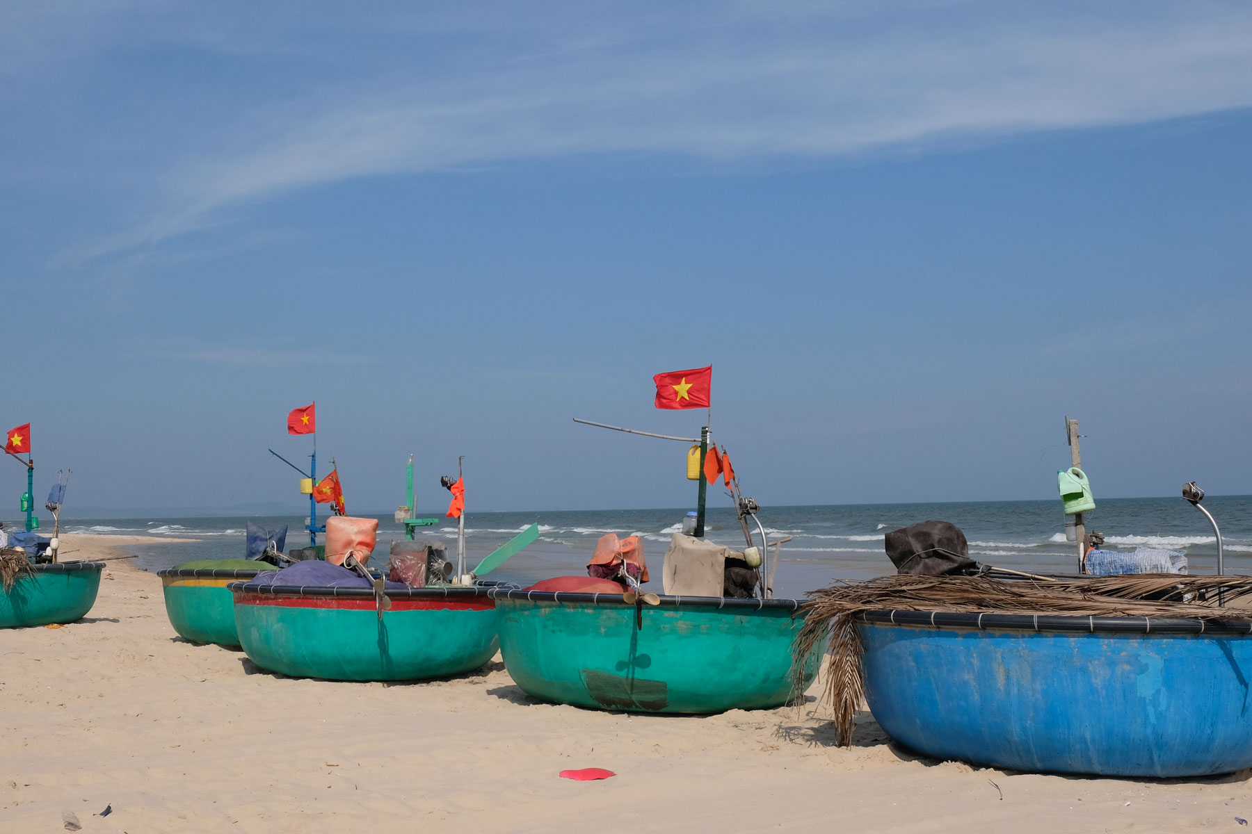 Runde Fischerboote liegen am Strand im Süden Vietnams.