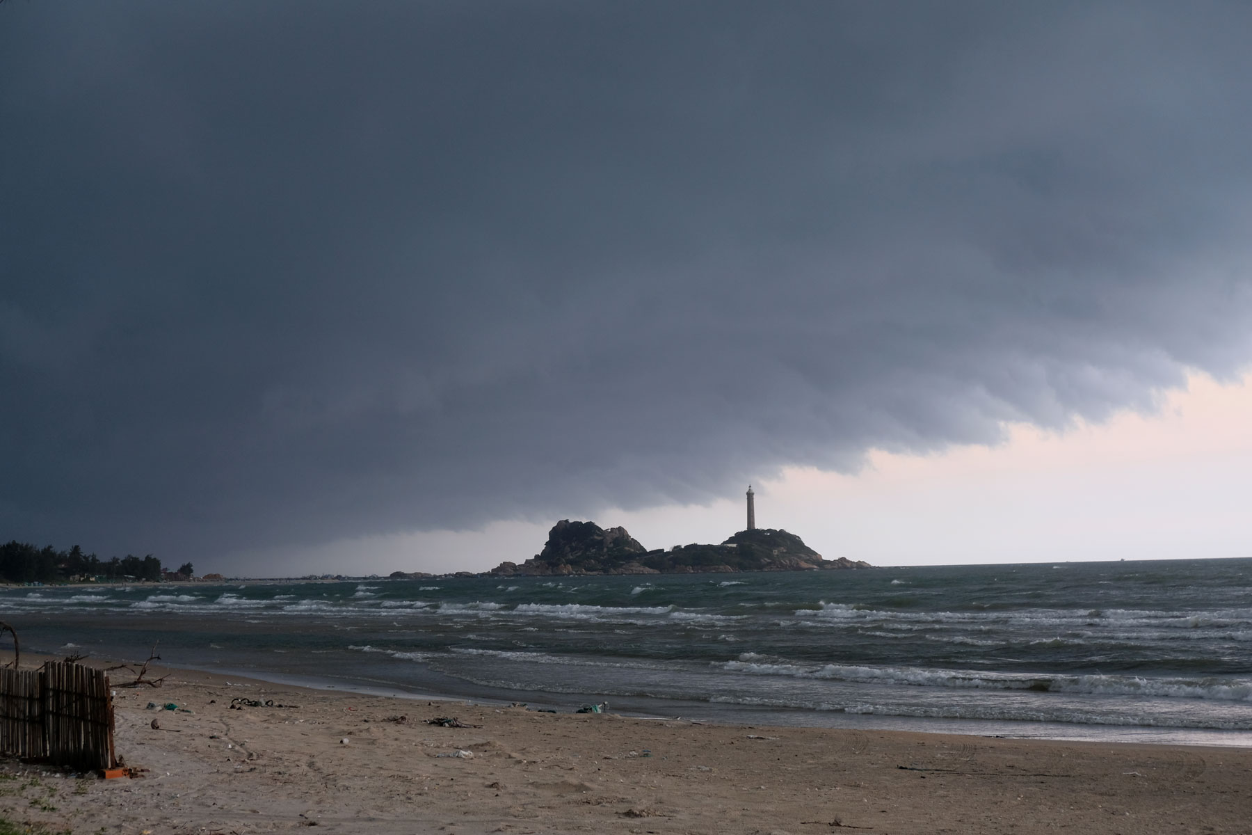 Dunkle Monsunwolken hängen über dem Leuchtturm von Văn Kê in Vietnam.