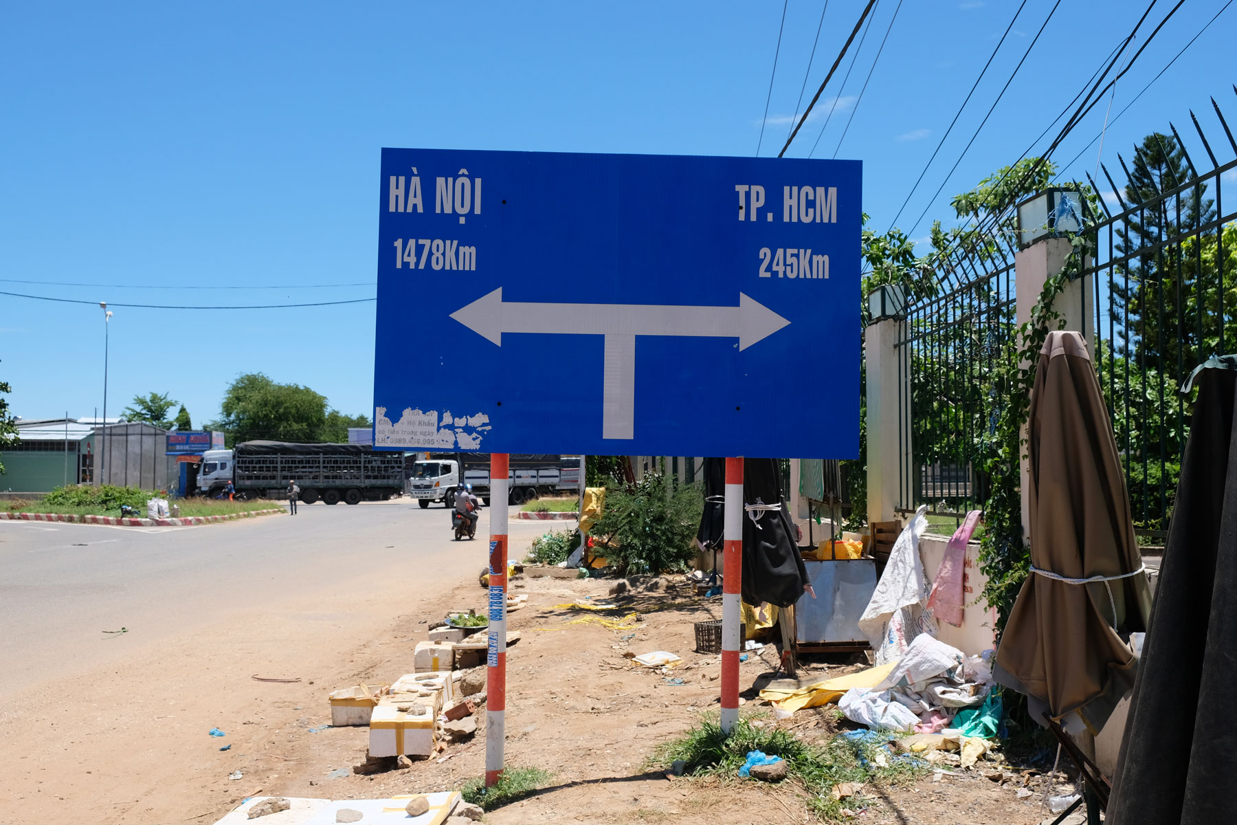 Ein Straßenschild informiert über die Entfernung in die vietnamesische Hauptstadt Hanoi und die größte Stadt Ho-Chi-Minh-City.