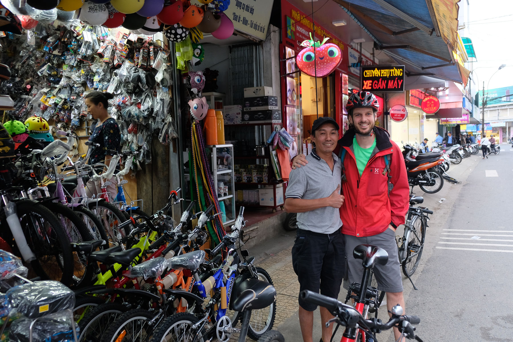 Sebastian steht mit Dinh vor einem vietnamesischen Fahrradgeschäft.