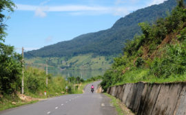 Leo fährt mit ihrem Fahrrad einen Berg im Hochland Vietnams hinunter.