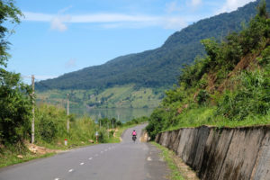Leo fährt mit ihrem Fahrrad einen Berg im Hochland Vietnams hinunter.