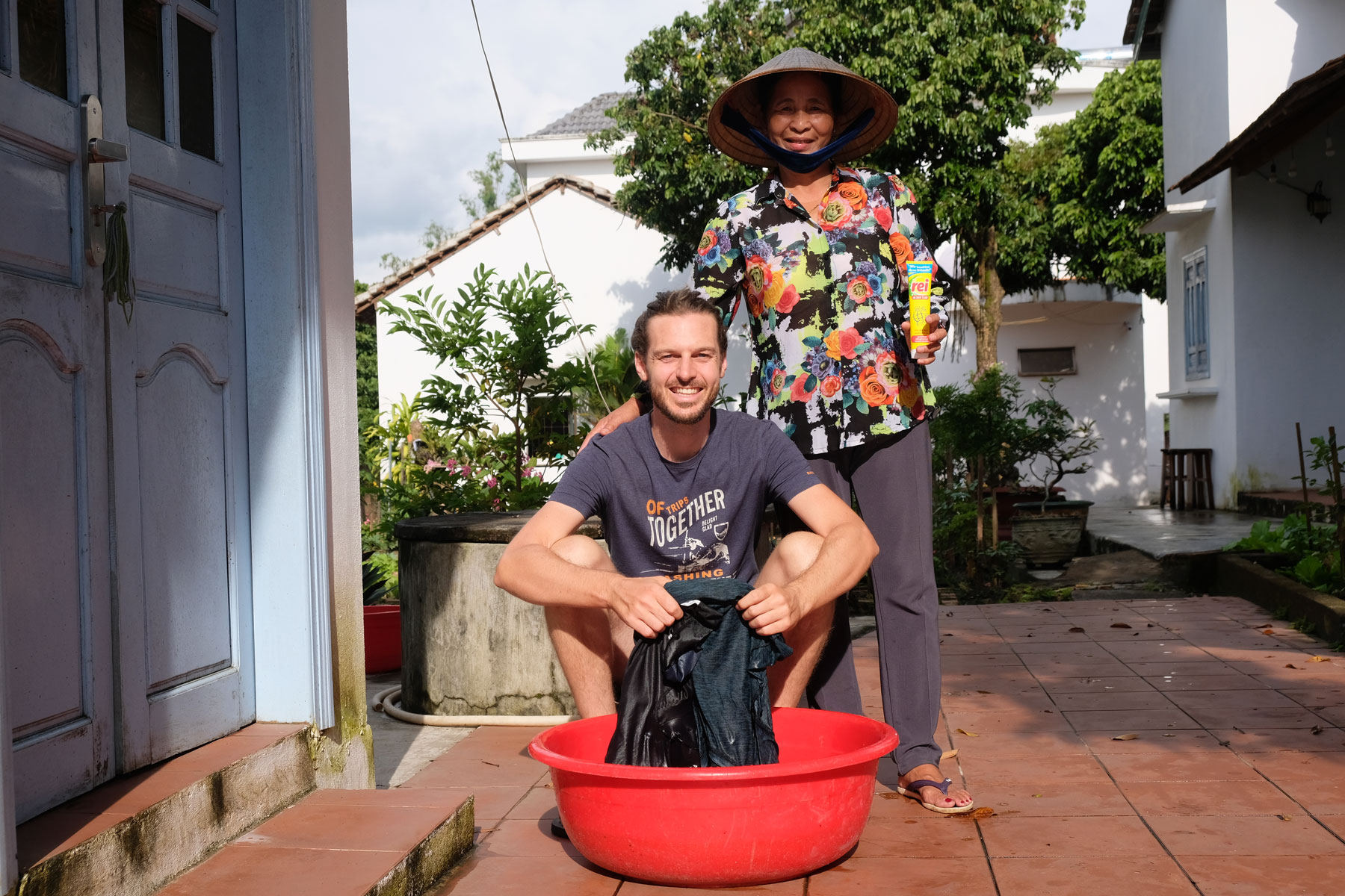 Sebastian wäscht seine Wäsche, neben ihm steht unsere vietnamesische Gastgeberin aus unserem Homestay in Kon Tum.