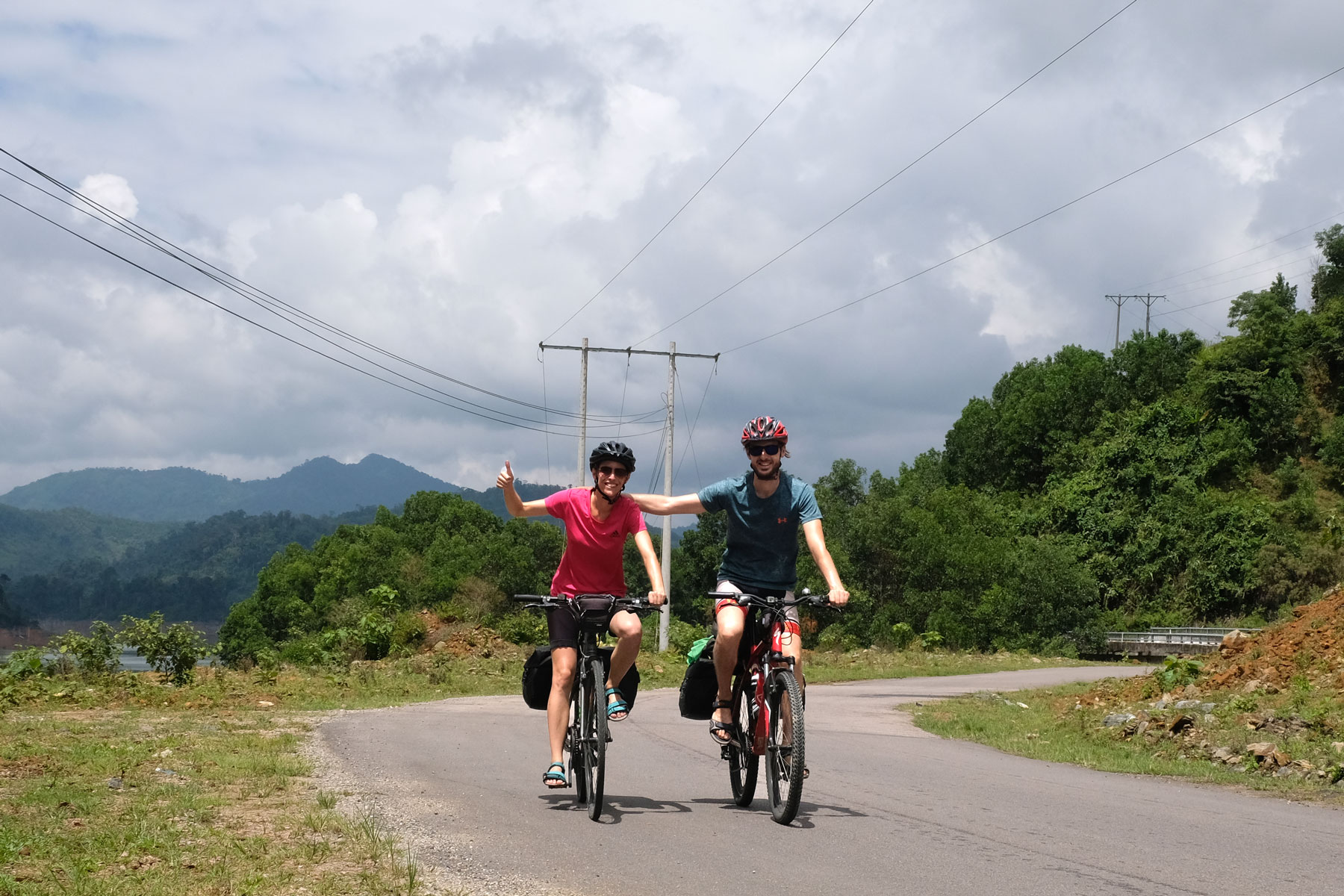 Leo und Sebastian fahren mit ihren Fahrrädern auf einer Straße im Hochland Vietnams.