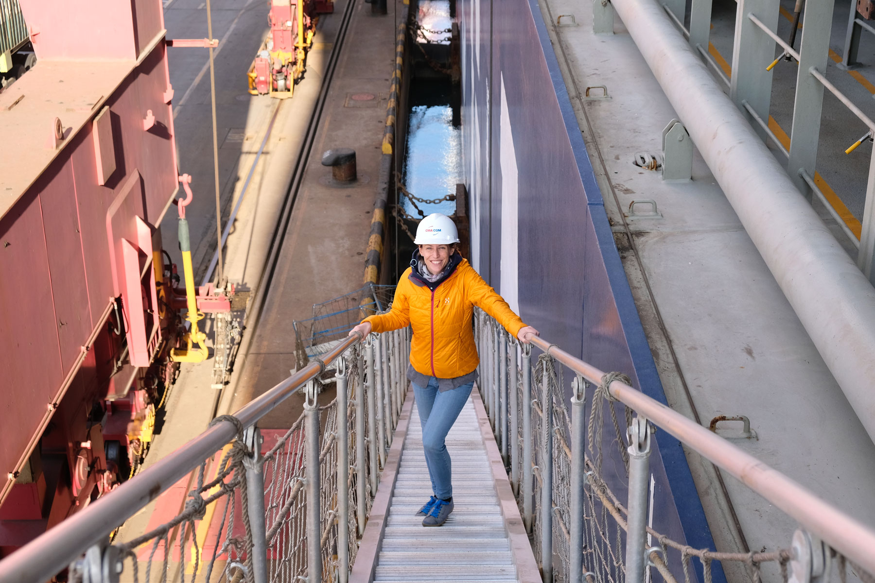 Leo betritt am Hafen von Qingdao über eine Gangway ein Containerschiff.