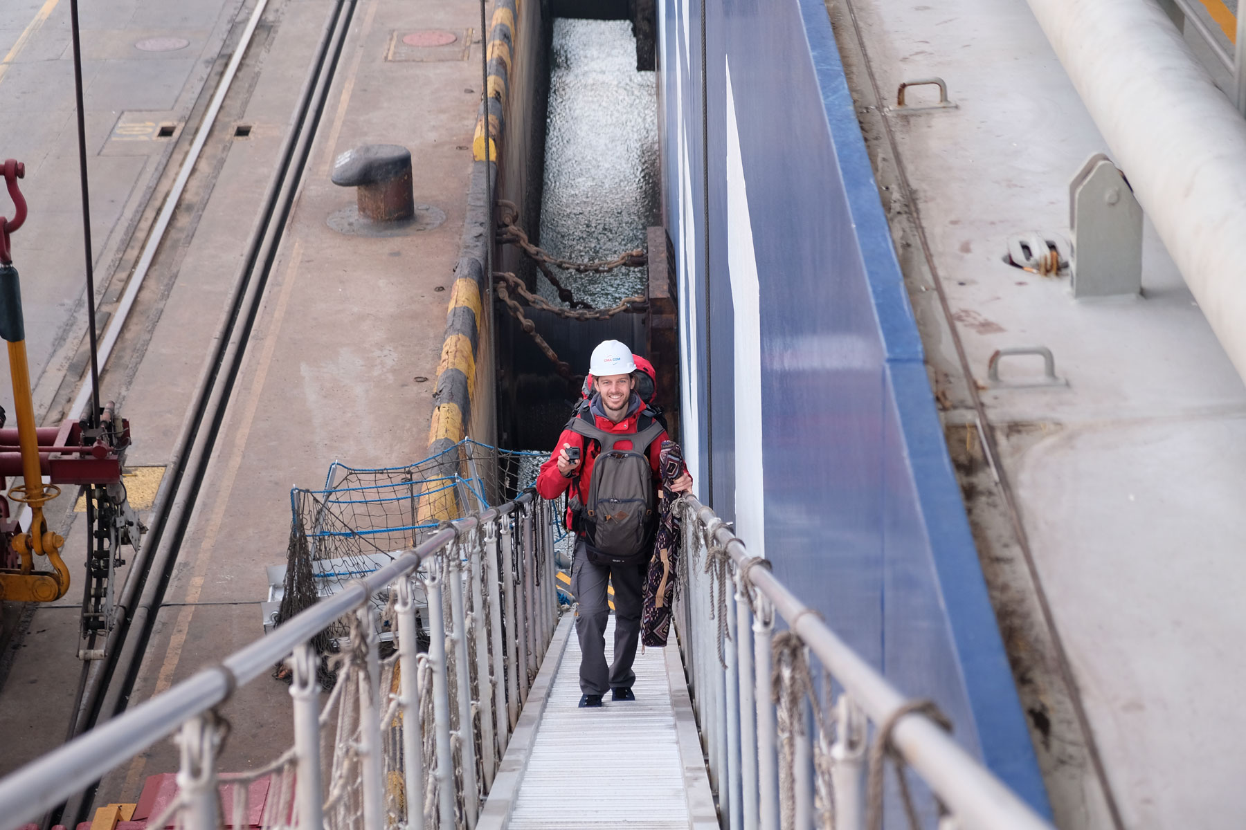 Sebastian betritt am Hafen von Qingdao über eine Gangway ein Containerschiff.