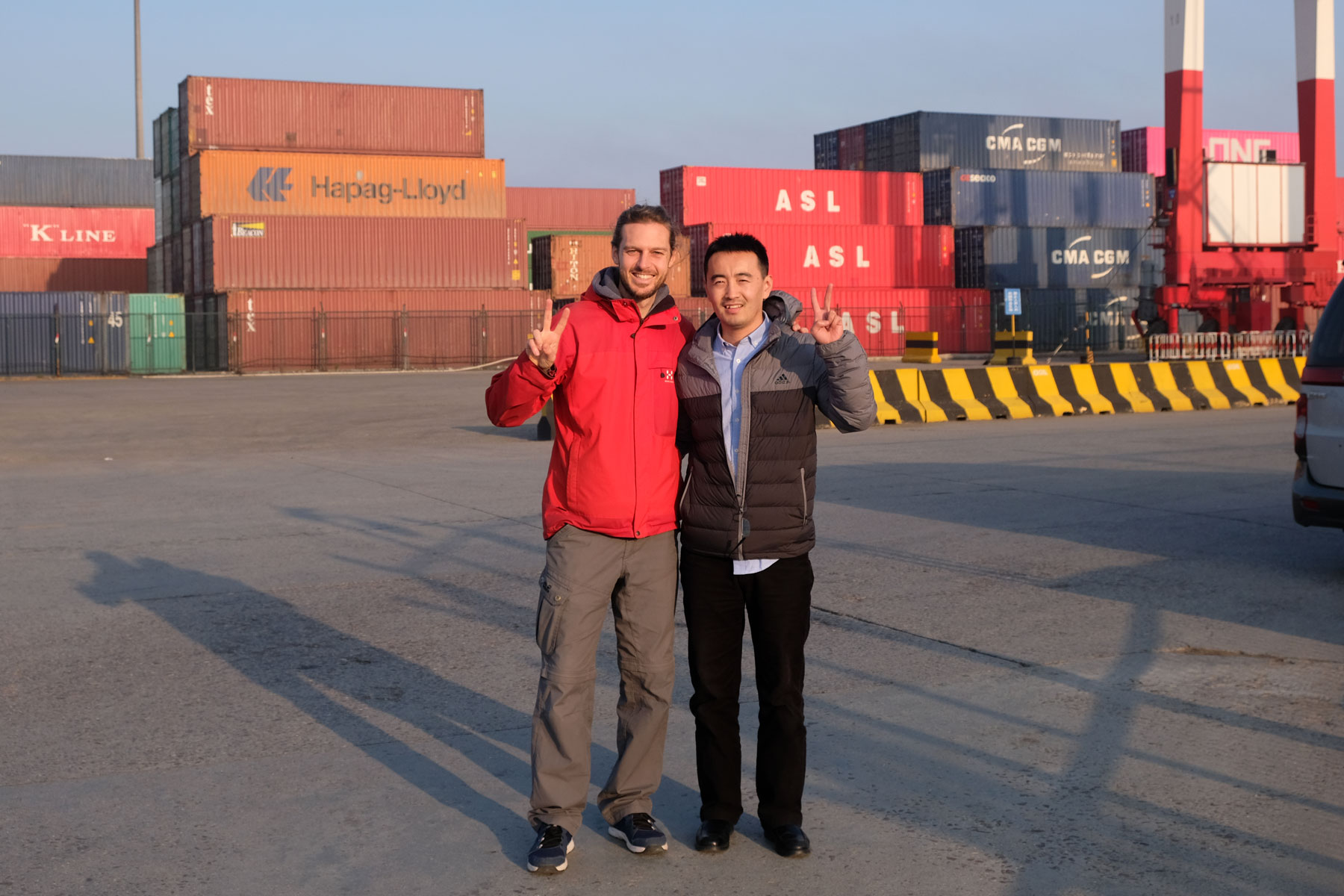 Sebastian mit einem Hafenagent am Hafen von Qingdao in China.